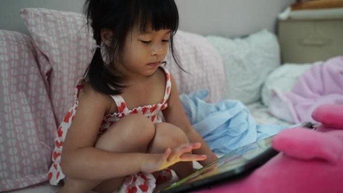 婴儿尝试玩ipad游戏，眼睛集中精力，在使用电子设备时小心照顾婴儿。