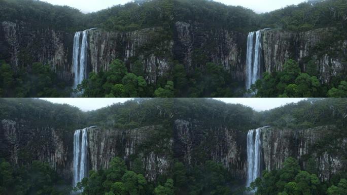 从热带雨林覆盖的山上溢出的雄伟瀑布的全景。澳大利亚睡帽国家公园Minyon Falls