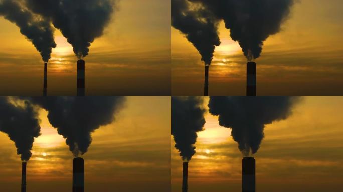 空气污染。植物的烟囱冒出浓烟，夕阳下美丽的金黄色。无人机飞越一家钢铁厂的吸烟烟囱。