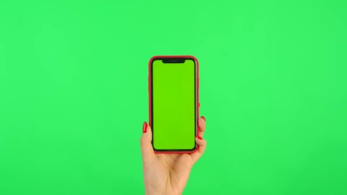 女人拿着绿色背景上带有工作区模拟屏幕的手机。女性手触摸，点击，点击，滑动，滑动，放大，缩小。广告区域
