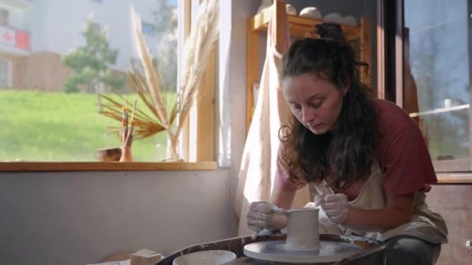 手工陶瓷制作，女师傅正在用陶轮做工