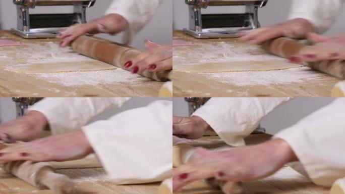 经验丰富的女人的手通过面团上的rolling面杖