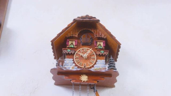 创意木制房屋形挂钟，快速摆动钟摆挂在空白色墙壁上，在家中近距离观看