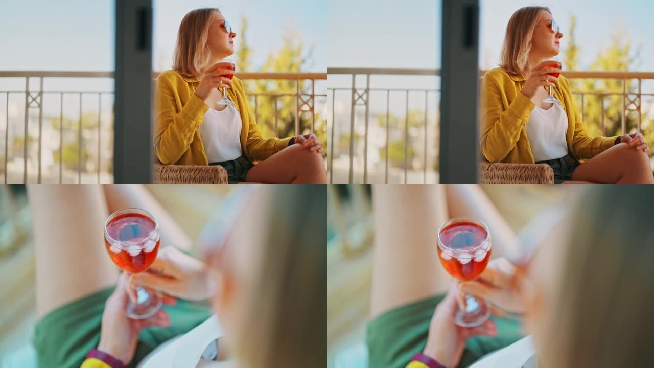 喝红酒的女人在阳台上享受假期。