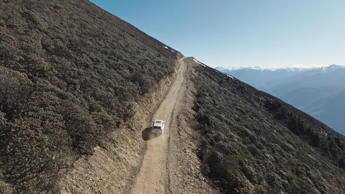 西藏林芝甲应村崇山峻岭中行驶的小车