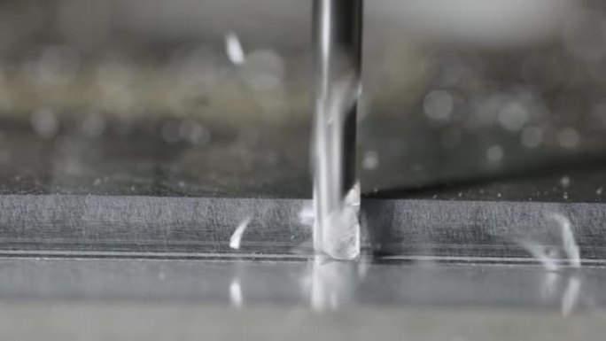 在数控钻头进行车床加工时，扭曲的多余金属碎片从铝片上飞出。铣床在高科技机械车间切割钢材的过程中。细节