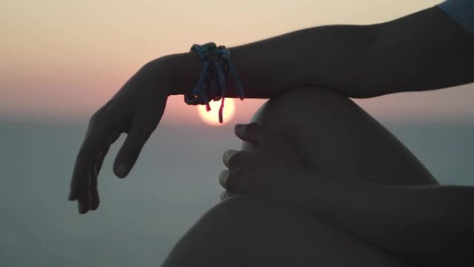 日落时女人手在海边的特写镜头。女孩在海边放松。地中海。电影冥想镜头。