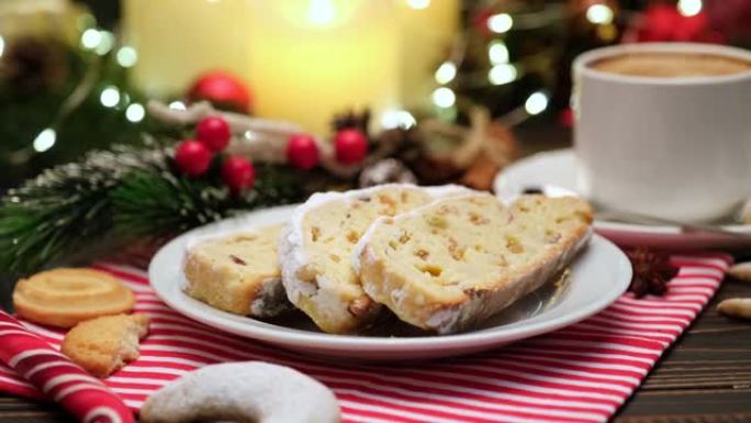 切片传统圣诞蛋糕，带杏仁饼和木制背景上的新年装饰
