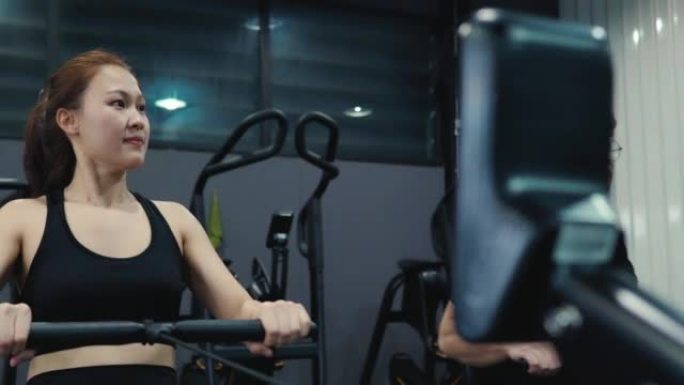4k视频片段，一个美丽的年轻女子喜欢在健身房用划船机锻炼身体