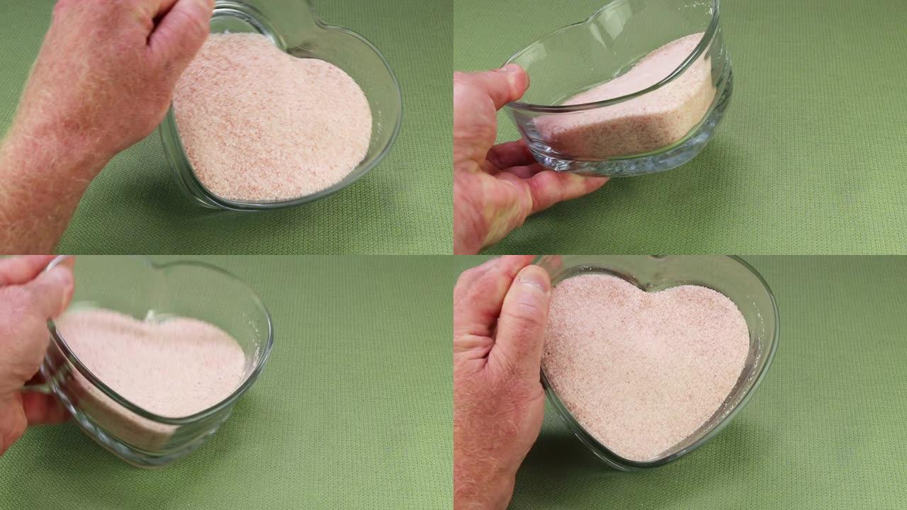 在心形盘子中显示细粒粉红色的喜马拉雅盐