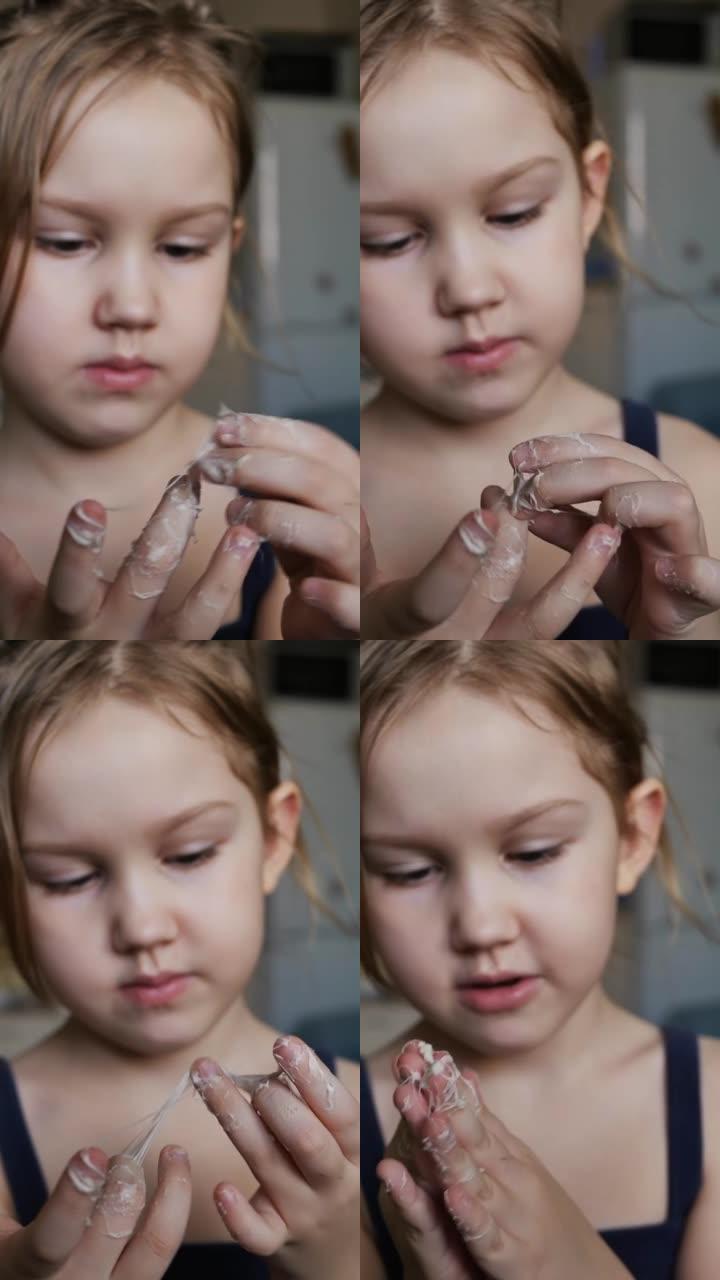 一个可爱的高加索学龄前女孩正在吃口香糖和手掌。口香糖粘在我的手掌和手指上。难以剥离粘液