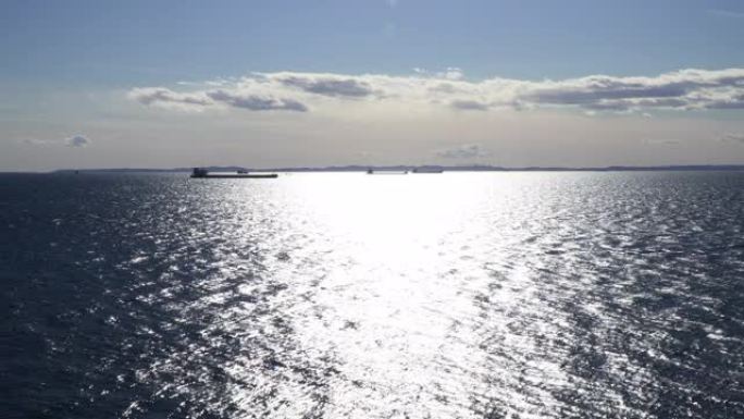 被太阳照亮的轮廓中的商船。停泊在东京湾的集装箱船。