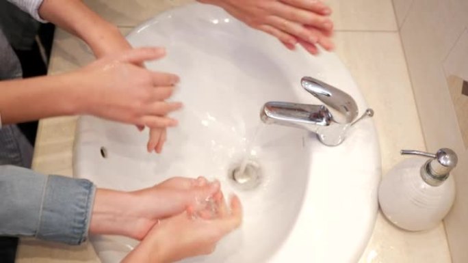 三个十几岁的孩子女孩姐妹在浴室的盥洗台上用肥皂洗手俯视图特写
