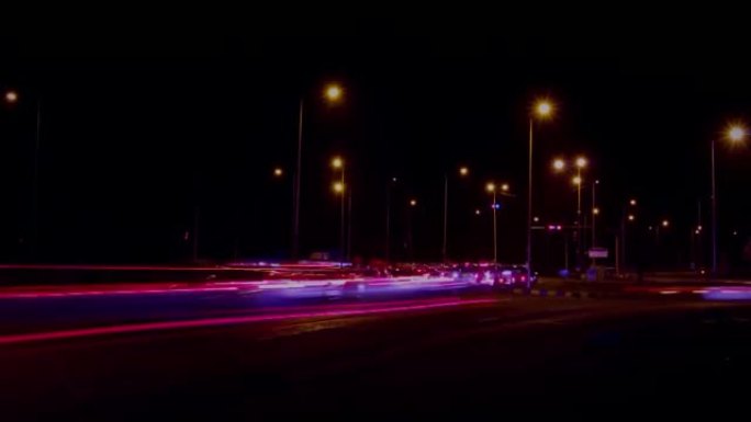 夜间道路信号灯处繁忙的交通线索。前往目的地的汽车的延时。