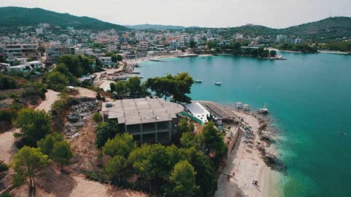 鸟瞰图蓝色海滩，带空日光浴躺椅，巴尔干海岸爱奥尼亚海阿尔巴尼亚