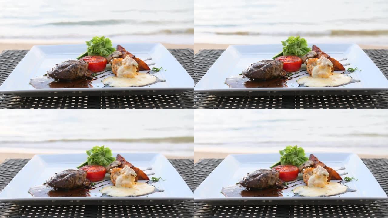 海浪度假餐厅海滩餐桌上的盘菲力牛排