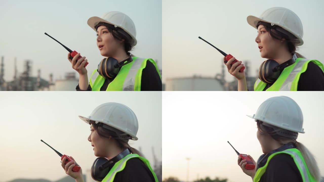 亚洲女工程师与无线电交谈，以控制建筑工作。