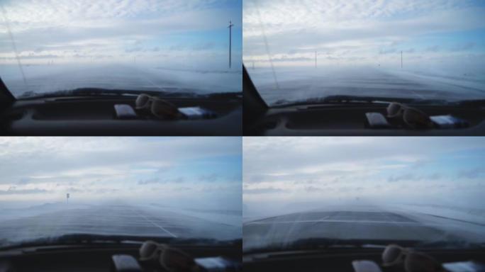高速公路上的大雪暴雪行驶时。透过挡风玻璃看。大风和霜冻。由于天气条件，能见度差