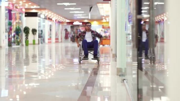 一个残疾人穿着衬衫坐着轮椅来到购物中心，看着橱窗