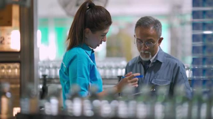亚洲中国装瓶厂厂长与生产线负责人就清单和饮用水生产进度进行沟通