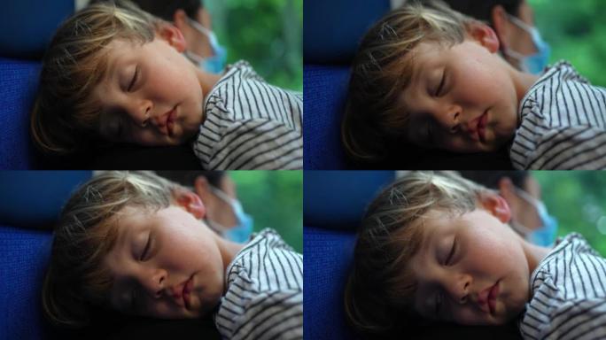小男孩睡在母亲的手臂上，乘火车小睡