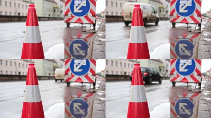 雨天驶过街道道路工程的汽车警告标志和安全锥