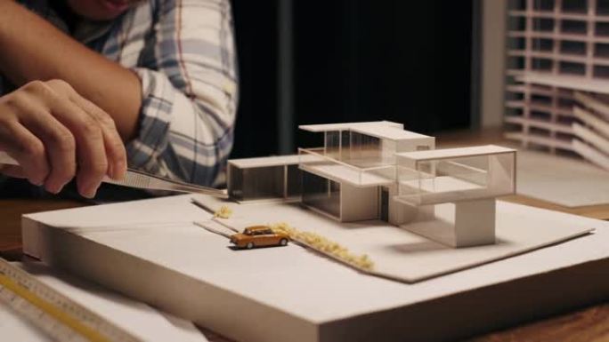 建筑师或工程师专业人员晚上在办公室的办公桌上处理建筑模型。