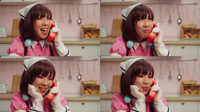 快乐迷人的亚洲女角色扮演者在固定电话上交谈的肖像