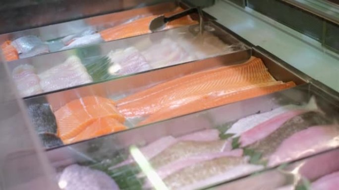 超市展示了各种各样的新鲜鱼片，展示了海洋产品。在一家准备寿司和其他鱼类菜肴的商店出售带有红色肉色的鲑