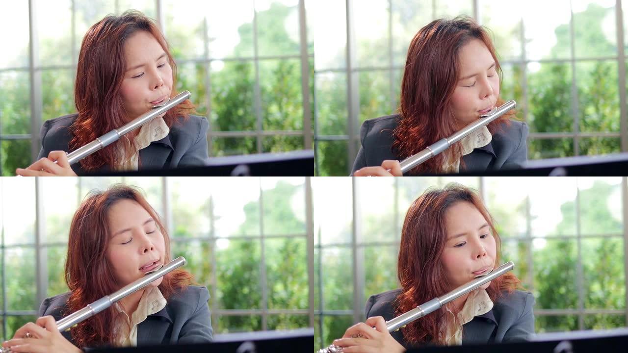 穿着西装的亚洲女老师她教古典音乐演奏长笛