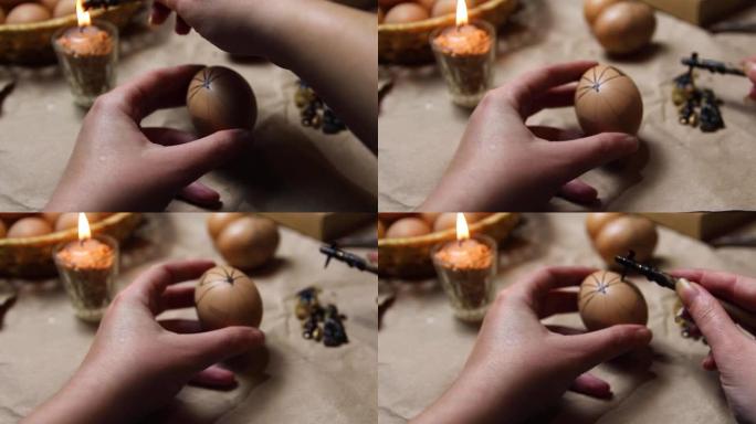 女性手握笔，pysachok和鸡蛋并绘画。准备用抗蜡法绘画乌克兰复活节彩蛋，装饰有民间设计。皮桑卡，