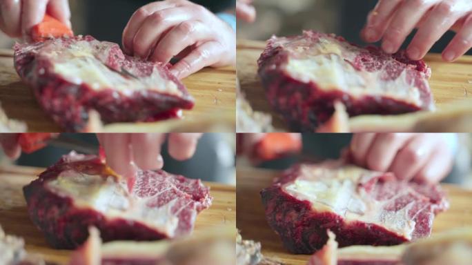 没有手套的人在木板上剥干肉，专业屠夫用锋利的刀从biltong切去皮。肉店干肉制造，猪肉干肉生产