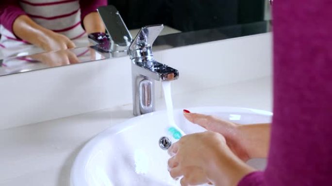 浴室水龙头上女性洗手牙刷的录像。4k分辨率的专业拍摄