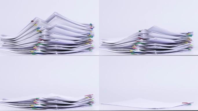 4k镜头视频停止堆叠纸落在白色背景上的运动，办公室中的无纸化概念。