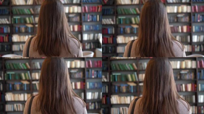 一个年轻的女学生走向书架的后视图。女人正在图书馆找他的书。慢动作