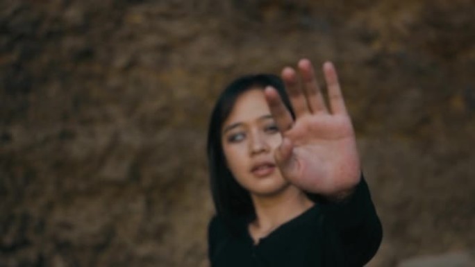 亚洲盲人妇女穿着黑色泳衣试图用手到达相机