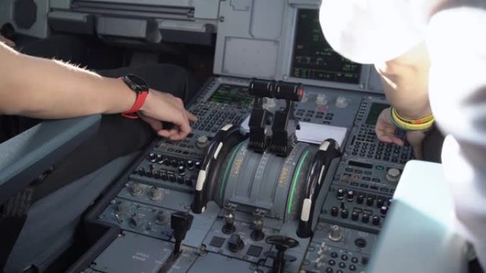 近距离拍摄操作商用飞机的机组人员，在驾驶舱飞行甲板控制面板内拍摄，机长兼副驾驶员讨论飞行路线，飞机系