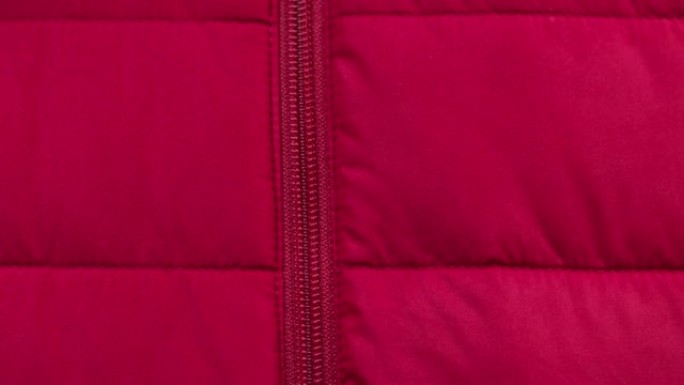 手拉开红色衣服特写。剪裁和缝纫概念。手工制作的东西，制衣，纺织品样品的宏观拍摄