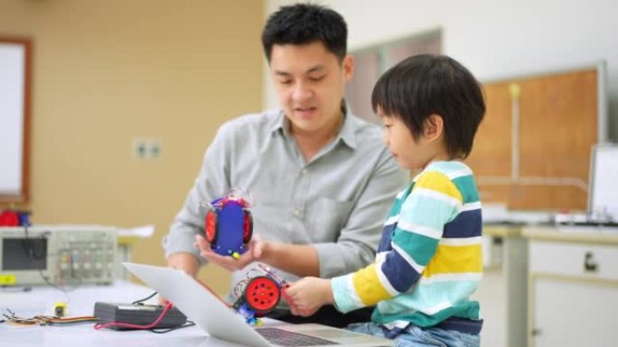 亚洲学生和老师使用电子仪表和笔记本电脑在科学课中构建自主自驱动机器人汽车的原型