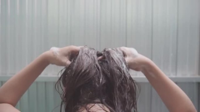 在浴室里，女人洗了头发，按摩了头发，揉了揉头发。