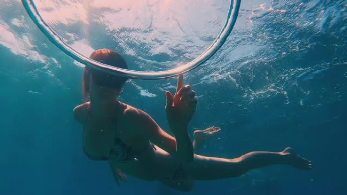 泡泡戒指。女自由潜水者在水下玩泡泡戒指