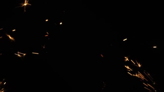 黑色背景上闪闪发光的孟加拉大火飞溅。黑暗中点亮烟火。闪闪发光的孟加拉烟花，带有金色的火花。假期，新年