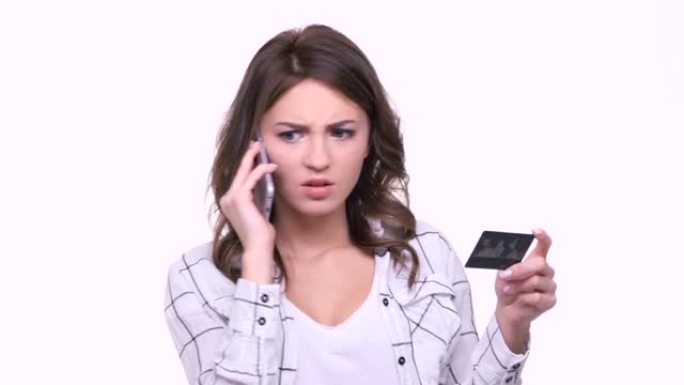 愤怒的年轻女子通电话并持有信用卡