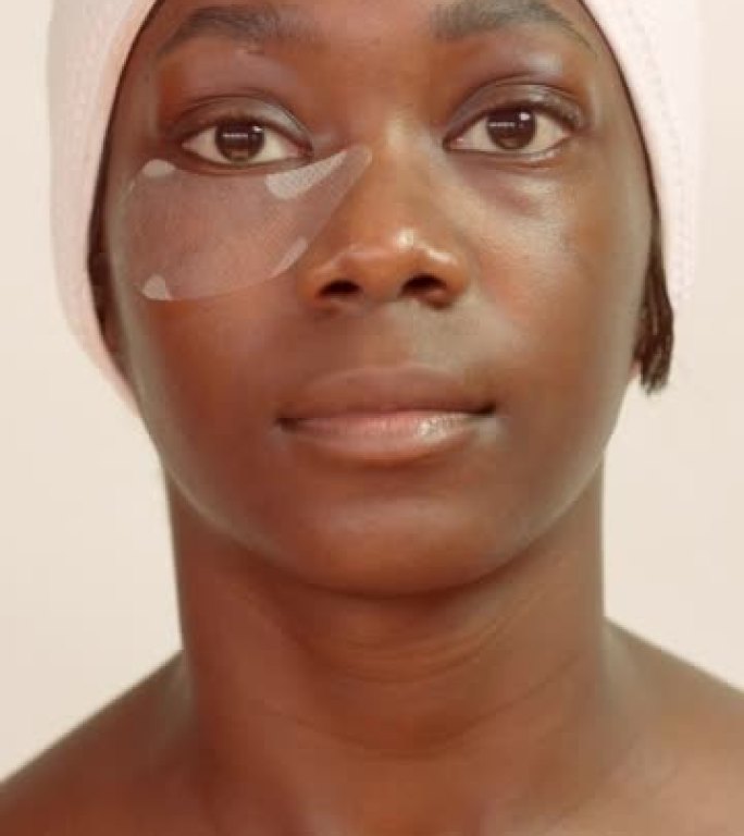 一名年轻女子接受眼部美容面部护理，以最大程度地减少浮肿和干燥
