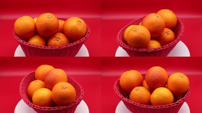 旋转新鲜橘子隔离在红色背景上。