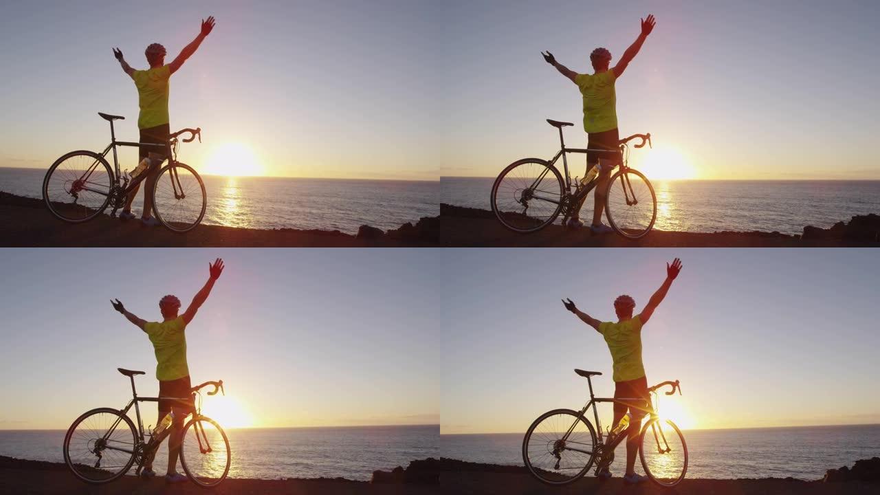 骑自行车的成功和成就 -- 男子欢呼在公路自行车上实现目标快乐。骑自行车的男性骑车人在日落时骑自行车