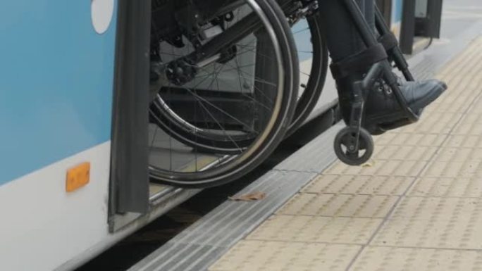 在公共汽车站坐轮椅的妇女下车/关门