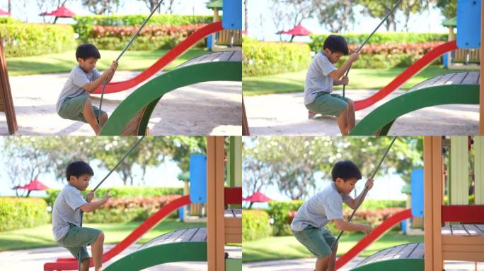 亚洲孩子在户外操场玩秋千和活动。学习户外和快乐的理念