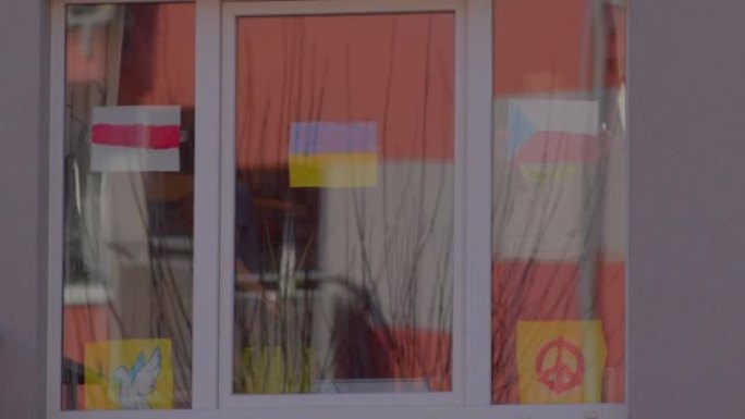 孩子们把旗子挂在窗户上。中间是乌克兰国旗。
