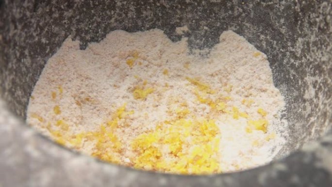 柠檬皮落入装满红糖和盐的石臼中的特写镜头